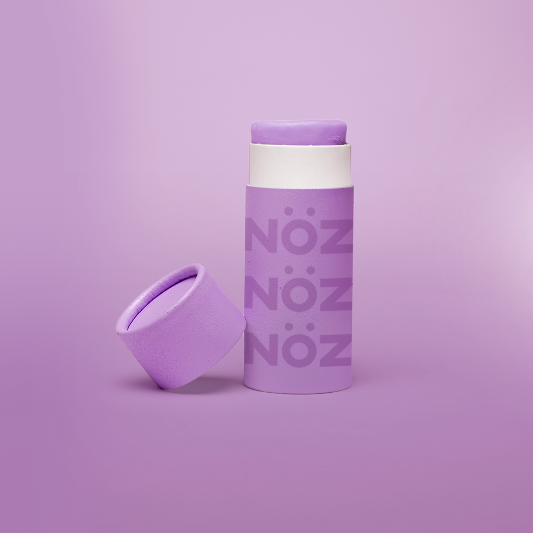 Purple bottle of sunscreen on a purple background.